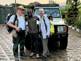 Clients pose for a photo with their guide after a successful Uganda wildlife safari